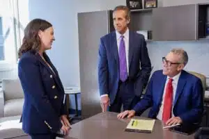 Medical malpractice attorneys, Jaime, John and Steve discussing a case at Steve Levin's desk.