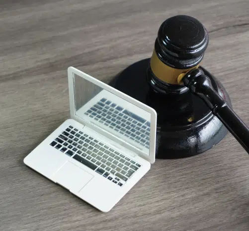 small white laptop with a gavel behind it