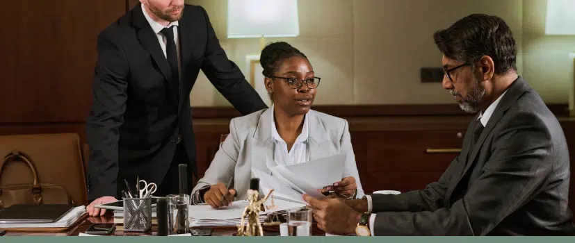 three people sitting around a conference table discussing a medical malpractice case