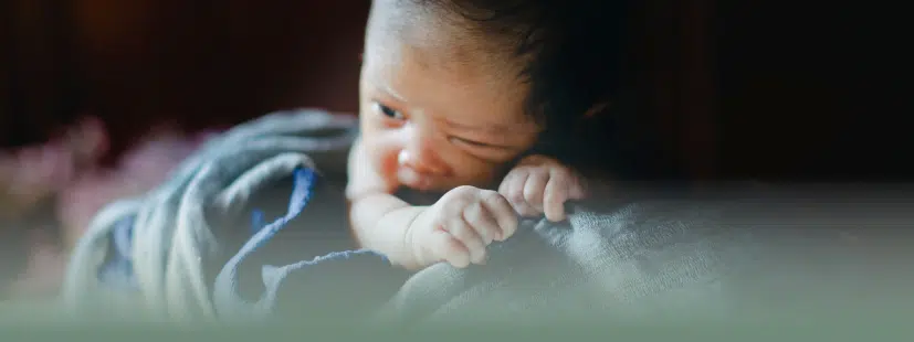 newborn baby being held over parent's shoulder